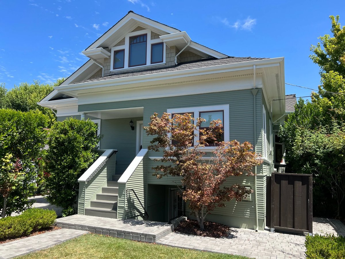 Two-story home painted in sage green with white trim