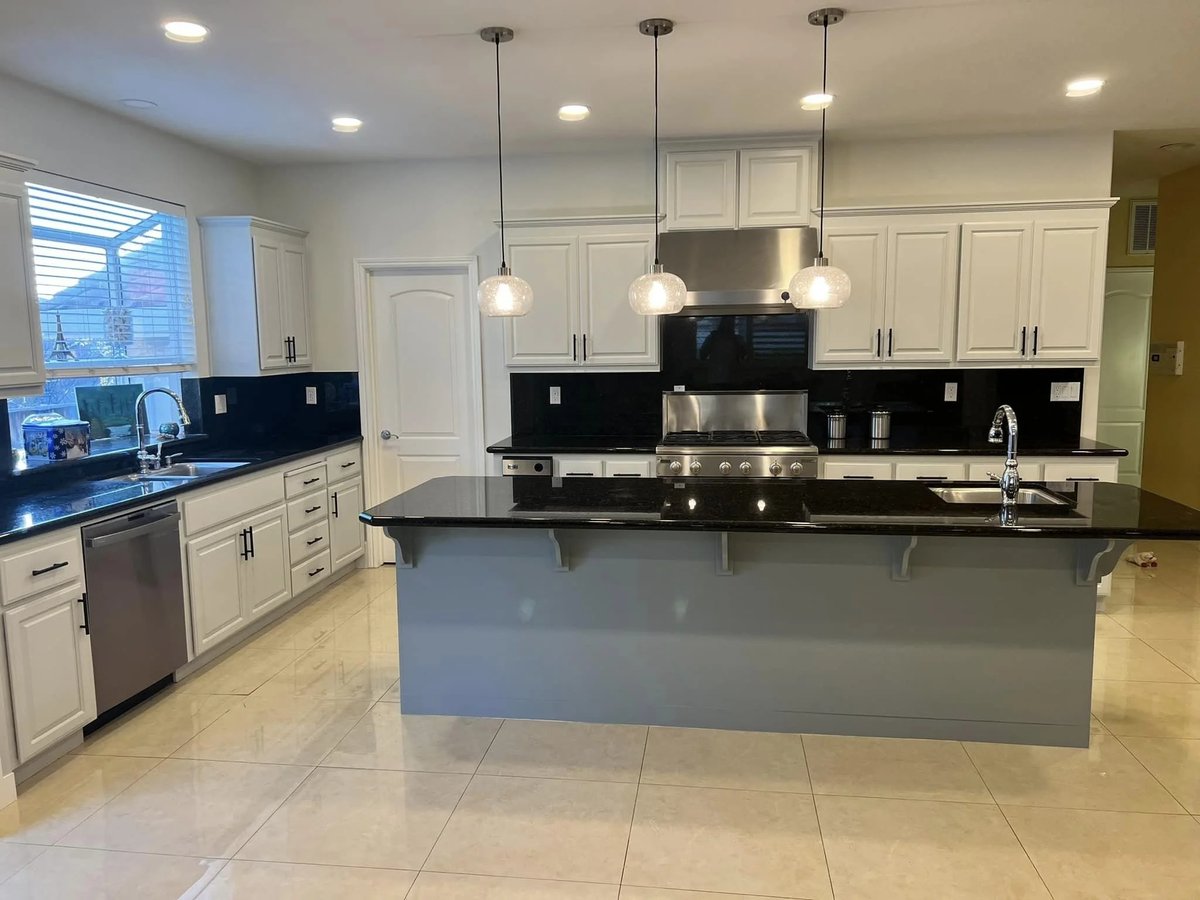 Finished kitchen with white cabinets and dark counters